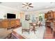 Cozy living room with elegant furnishings, a ceiling fan, and large windows bringing in natural light at 8033 Pawleys Ct, Fort Mill, SC 29707
