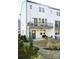 White townhouse with black trim, balcony and walk-out patio in a landscaped yard at 8044 Cedarsmith Ct, Charlotte, NC 28217