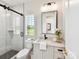 Bright bathroom featuring a glass shower, modern vanity, and window with shutter-style blinds at 8108 Farm Crossing Ln # 26, Huntersville, NC 28078