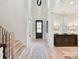 Bright entryway featuring a hardwood floor, staircase with black railings, and modern light fixture at 8108 Farm Crossing Ln # 26, Huntersville, NC 28078
