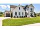 Charming two-story farmhouse with beautiful landscaping, manicured lawn, and modern black and white accents at 8108 Farm Crossing Ln # 26, Huntersville, NC 28078