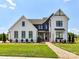 Stunning two-story farmhouse with beautiful landscaping, manicured lawn, brick pathway, and modern black and white accents at 8108 Farm Crossing Ln # 26, Huntersville, NC 28078