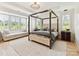 Spacious main bedroom with stylish four-poster bed, sitting area, and abundant natural light from large windows at 8108 Farm Crossing Ln # 26, Huntersville, NC 28078