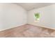 A well-lit bedroom with soft carpet and view to the outside from a window at 8316 Highgate Dr, Charlotte, NC 28215