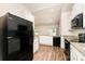 Modern kitchen featuring black appliances, granite countertops, white cabinets, and wood floors at 8316 Highgate Dr, Charlotte, NC 28215