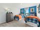 Cozy bedroom featuring two beds, a dresser, and a bright blue accent wall at 833 Hallman Branch Ln, Lincolnton, NC 28092