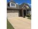 Charming home with stone accents, a two-car garage, and a well-manicured lawn on a sunny day at 10039 St Kitts Landing Ln, Charlotte, NC 28278
