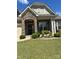 Close up of a home featuring a stone archway entry and a well-maintained lawn with colorful landscaping at 10039 St Kitts Landing Ln, Charlotte, NC 28278