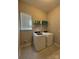 Functional laundry room features modern appliances, a window for light, and shelving for storage at 10039 St Kitts Landing Ln, Charlotte, NC 28278