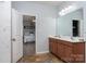 Bright bathroom featuring double vanity with wood cabinets, tile flooring, and an open view to the bedroom at 109 Meadow Stream Dr, Mount Holly, NC 28120