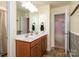 Bright bathroom featuring double vanity with wood cabinets, tile flooring, and a view to the bedroom at 109 Meadow Stream Dr, Mount Holly, NC 28120
