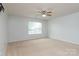 Spacious bedroom with neutral carpet, a ceiling fan, and a bright window with natural light at 109 Meadow Stream Dr, Mount Holly, NC 28120