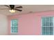 Bedroom featuring bright pink walls, window with blinds and a ceiling fan, complemented by neutral-colored carpet at 109 Meadow Stream Dr, Mount Holly, NC 28120