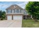 Charming two-story home with a manicured lawn, featuring a two-car garage and stone accents at 109 Meadow Stream Dr, Mount Holly, NC 28120
