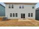 Backyard featuring patio area, grass, and neutral color siding with multiple windows at 110 Obadiah Ct, Mooresville, NC 28115
