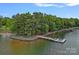 Picturesque aerial view of a private waterfront peninsula with a dock, lush trees, and serene water at 112 Nautilus Ct, Troutman, NC 28166