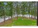 Expansive backyard with lush green grass and lots of trees leading down to the lake at 112 Nautilus Ct, Troutman, NC 28166