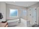 Modern bathroom featuring a soaking tub, frameless shower, and large window at 112 Nautilus Ct, Troutman, NC 28166