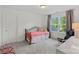 Minimalist bedroom with natural light, neutral carpet, and a small bed with dark metal frame at 112 Nautilus Ct, Troutman, NC 28166