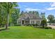 Beautiful home boasts a lush lawn, well-maintained landscaping, and a stately stone and siding facade at 112 Nautilus Ct, Troutman, NC 28166