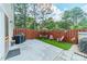 Private backyard patio with artificial grass, a grill, seating, and a charming fence, ideal for relaxing outdoors at 11515 Retriever Way, Charlotte, NC 28269