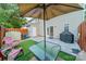 Relaxing backyard patio with artificial grass, a grill, seating, and a cozy umbrella, perfect for outdoor gatherings at 11515 Retriever Way, Charlotte, NC 28269