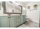 Nicely updated bathroom with dual sinks, a large mirror, cute decor, and blue-green cabinets at 11515 Retriever Way, Charlotte, NC 28269