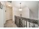 Well-lit upstairs hallway with wooden railings, a light fixture, and neutral colored carpet at 11515 Retriever Way, Charlotte, NC 28269