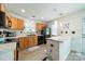Kitchen with oak cabinets, a black appliance suite and an island with seating at 11515 Retriever Way, Charlotte, NC 28269