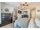 Comfortable main bedroom features wood-look flooring, a ceiling fan, walk-in closets, and a TV mounted to the wall at 11515 Retriever Way, Charlotte, NC 28269