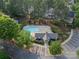 Aerial view of a community pool and clubhouse surrounded by lush trees, offering a relaxing and recreational space at 11515 Retriever Way, Charlotte, NC 28269