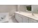 Bright bathroom with white cabinets, countertop, tub, and tile flooring at 12013 Regent Ridge Ln, Charlotte, NC 28278