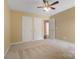 Bedroom with carpet, ceiling fan, and multiple white doors for closet and access at 12013 Regent Ridge Ln, Charlotte, NC 28278