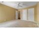 Bedroom with carpet, ceiling fan, and multiple white doors for closet and access at 12013 Regent Ridge Ln, Charlotte, NC 28278