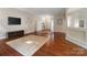 Spacious open-concept living room with hardwood floors, ceiling fan, and TV at 12013 Regent Ridge Ln, Charlotte, NC 28278