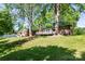 View of the back of the brick home, with a wooden deck, and a large grassy yard at 1211 Starlight Dr, Shelby, NC 28152