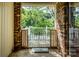 Covered entryway with a wrought iron gate, brick columns, and a view of the deck at 1211 Starlight Dr, Shelby, NC 28152