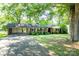 Charming one-story brick home with black shutters and a covered carport under mature trees at 1211 Starlight Dr, Shelby, NC 28152