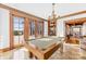 Inviting game room with a classic billiards table, marble floors, and views of the outdoor living space at 12613 Oak Grove Rd, Stanfield, NC 28163