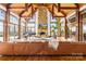Grand living room with exposed wood beams, stone fireplace, floor-to-ceiling windows, and piano at 12613 Oak Grove Rd, Stanfield, NC 28163