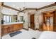 Chic main bathroom featuring dual vanities, designer wallpaper, a chandelier, and a doorway to the bedroom at 12613 Oak Grove Rd, Stanfield, NC 28163