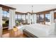 Bright main bedroom with hardwood floors, tray ceiling, white linens, and scenic views from large windows at 12613 Oak Grove Rd, Stanfield, NC 28163