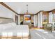 Luxurious main bedroom with hardwood floors, tray ceiling, elegant chandelier, and abundant natural light at 12613 Oak Grove Rd, Stanfield, NC 28163