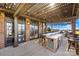 Covered outdoor kitchen with bar seating, stainless steel appliances, and views of the lush backyard at 12613 Oak Grove Rd, Stanfield, NC 28163
