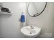 Powder room featuring a corner sink and a black framed circular mirror at 13032 Windy Lea Ln, Huntersville, NC 28078