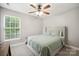 Bedroom with a ceiling fan, large window, and a full bed with gray carpet flooring at 13032 Windy Lea Ln, Huntersville, NC 28078