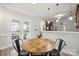 Cozy dining area featuring a round wooden table and black metal chairs, adjacent to the stylish kitchen at 13032 Windy Lea Ln, Huntersville, NC 28078
