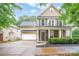 Charming two-story home with a welcoming front porch and stone accents and an attached two-car garage at 13032 Windy Lea Ln, Huntersville, NC 28078