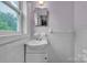 Neat bathroom with white tile, a sink with a cabinet, and a mirrored medicine cabinet at 133 Jo Monni Loop, Statesville, NC 28625
