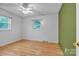 Bright bedroom features hardwood floors, a ceiling fan, and two windows at 133 Jo Monni Loop, Statesville, NC 28625